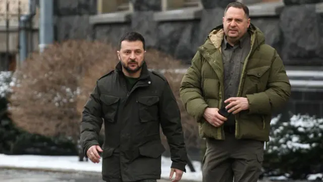 Зеленский и Ермак идут по заснеженной улице. Они одеты в зимнюю одежду оливкового цвета