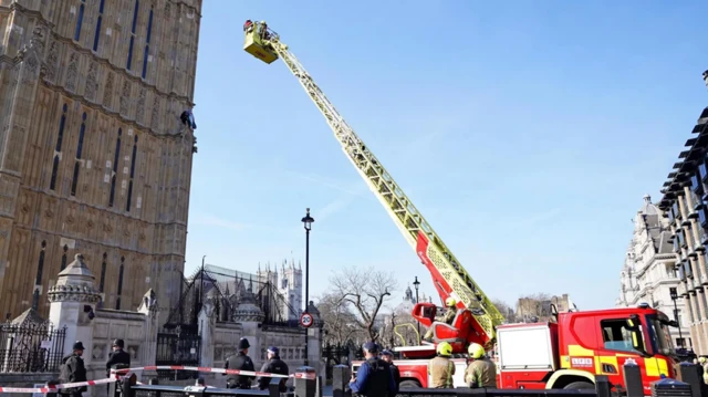 خدمات الطوارئ أسفل برج إليزابيث الذي يضم ساعة بيغ بن حيث تسلق رجل حاملاً علم فلسطين