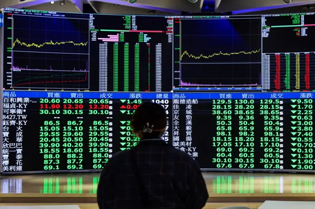 زنی در حال تماشای بازار بورس در تایوان
