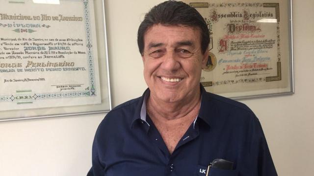 Jorge Perlingeiro sorrindo para fototodos os jogos de cassinofrente a certificados