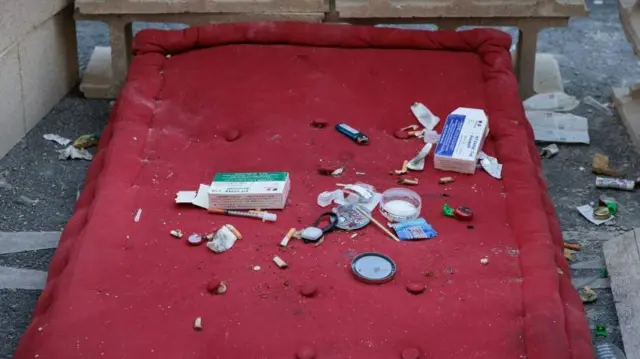 Jarum suntik bekas pecandu narkoba dan kotak berisi alat pencegahan HIV dan hepatitis ditinggalkan di rue de Barbes, utara Paris, pada Sabtu (11/05).