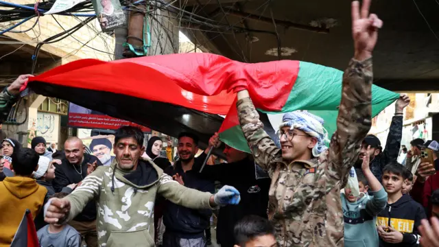 صورة لفلسطينيين يحتفلون بوقف إطلاق النار في غزة، في مخيم برج البراجنة للاجئين الفلسطينيين قرب بيروت.