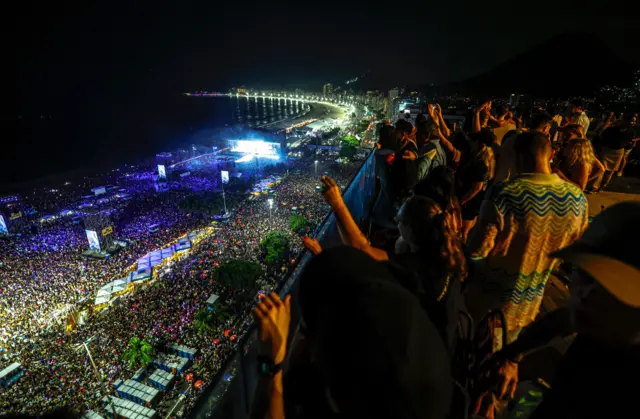 Pessoas veem o show da Shakira de um terraço