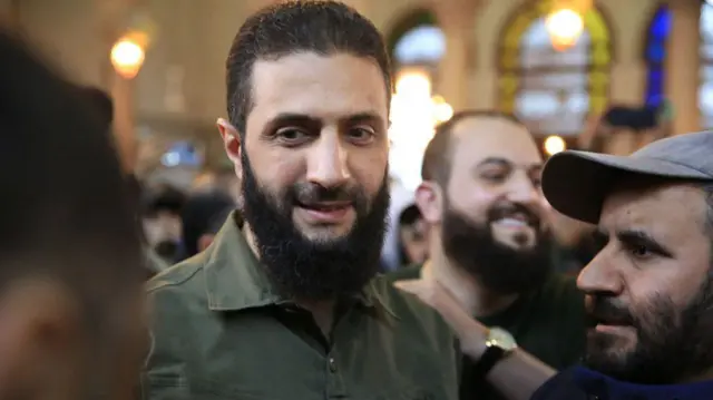 Supporters welcome the leader of Syria's Islamist Hayat Tahrir al-Sham (HTS) group Abu Mohammed al-Jolani before his address at the capital's landmark Umayyad Mosque 