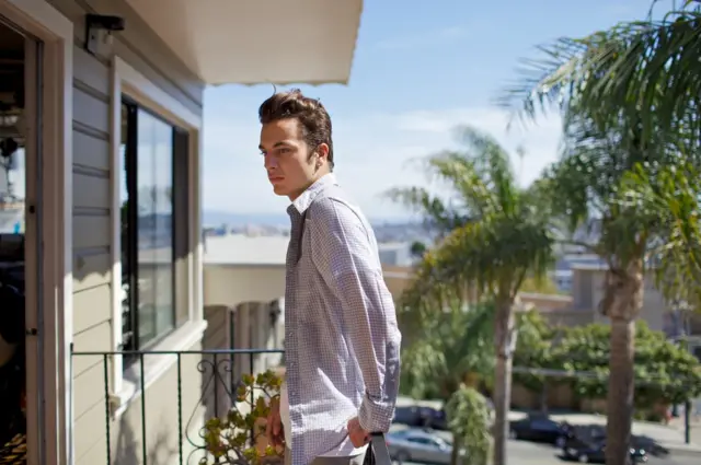 A portrait of a young man on a balcony