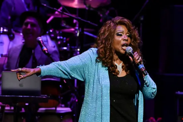 Gloria Gaynor en un escenario cantando. 