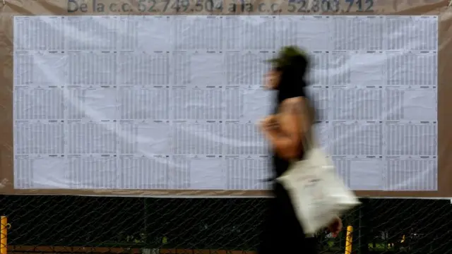 Mujer circula por delante del padrón en Colombia.