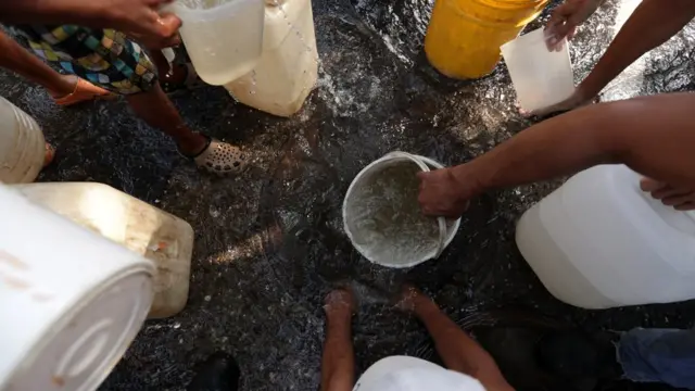 Gente recogiendo agua.