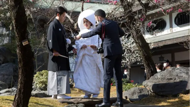 Pareja de recién casados tomándose fotos en Tokio.