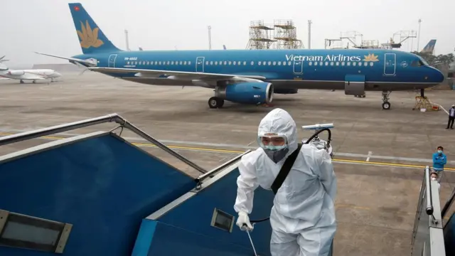 Man in protective suit boarding plane