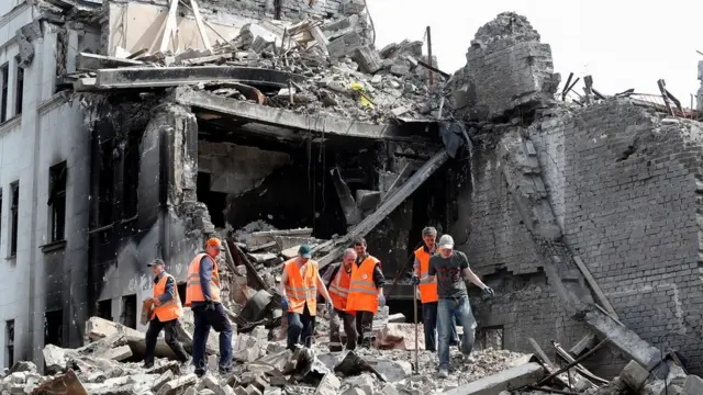 Люди разгребают завалы на месте драмтеатра в Мариуполе