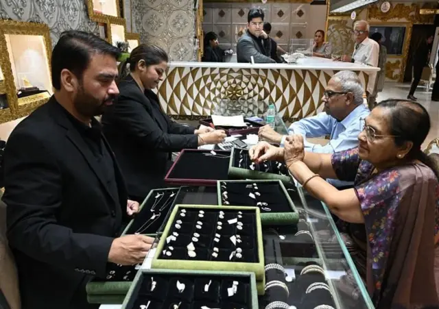 सोन्याच्या दुकानात ग्राहक दागिने पाहताना