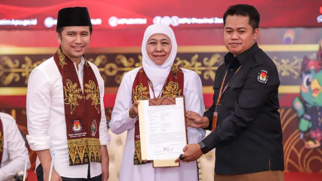 Ketua KPU Jatim Aang Kunaifi (kanan) menerima surat pernyataan visi, misi, dan program bakal calon Gubernur dan Wakil Gubernur Jawa Timur Khofifah Indar Parawansa (tengah) dan Emil Elestianto Dardak (kiri) saat pendaftaran di Kantor KPU Provinsi Jawa Timur, Surabaya, Jawa Timur, Rabu (28/8/2024). Khofifah Indar Parawansa dan Emil Elestianto Dardak resmi mendaftarkan diri sebagai peserta Pilgub Jatim 2024 dengan dukungan 15 partai yakni Gerindra, Golkar, Demokrat, NasDem, Perindo, PAN, PKS, PPP, PSI, PKN, PBB, Partai Gelora, Partai Buruh, Partai Garuda, dan Partai Prima. 