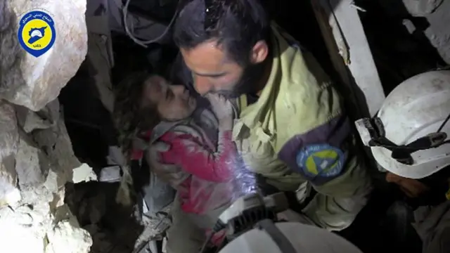 Rescatistas ayudan a un niño sirio entre los escombros de Alepo