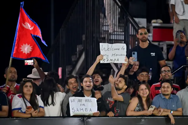 साम्बालाई सिड्नीमा वेस्टर्न वान्डरर्स र वेलिङ्टन फीनिक्सबीचको खेलमा स्वागत गर्दै नेपालको झण्डा बोकेका नेपाली दर्शकहरू