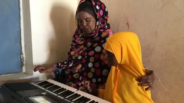 Gabadh ardayda ka mid ah oo la barayo muusig