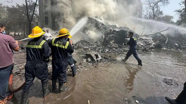 Tim gabungan berusaha memadamkan kobaran api setelah pesawat jatuh di Ahmedabad, Kamis (12/06).