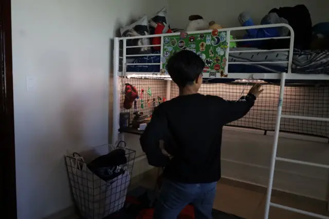 El hijo de Montserrat Caballero, presidenta municipal de Tijuana, muestra su habitación en la casa en la que vive en el 28 Batallón de Infantería de la ciudad mexicana en agosto de 2023.