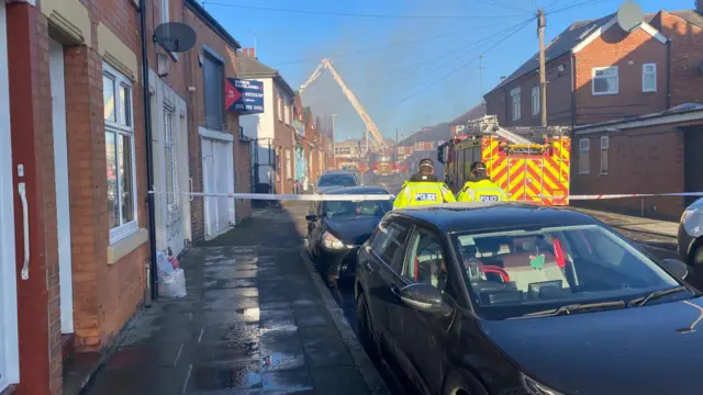 Cordón policial y bomberos trabajan para combatir el incendio en una propiedad comercial en Marjorie Street en Leicester