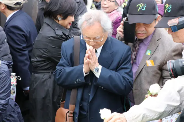 献花仪式上许多人双手合十，替过去亡故的长辈致意