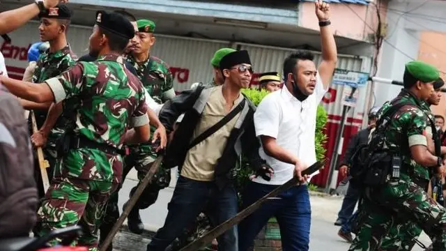 TNI berusaha menenangkan kelompok Muslim yang meneriakkan slogan saat bersitegang dengan kelompok masyarakat Dayak di Pontianak, Kalimantan Barat pada Sabtu (20/05).