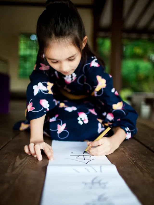 niña escribe en un papel