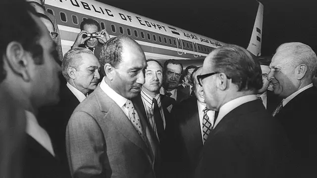 ১৯৭৭ সালের ১৯শে নভেম্বর মি. সাদাতের বিমান ইসরায়েলের বেন গুরিয়ান বিমানবন্দরে অবতরণ করার পর তাকে স্বাগত জানাচ্ছেন ইসরায়েলের প্রধানমন্ত্রী মি. বেগিন