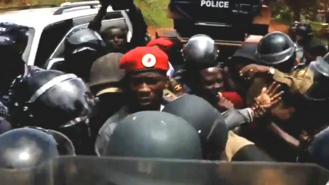 Bobi Wine (wambaye ingofero itukura) ubwo yatabwaga muri yombi na polisi ya Uganda