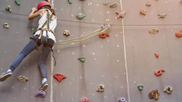 Una mujer escala en una pared