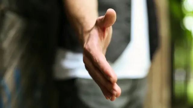 persona tendiendo la mano