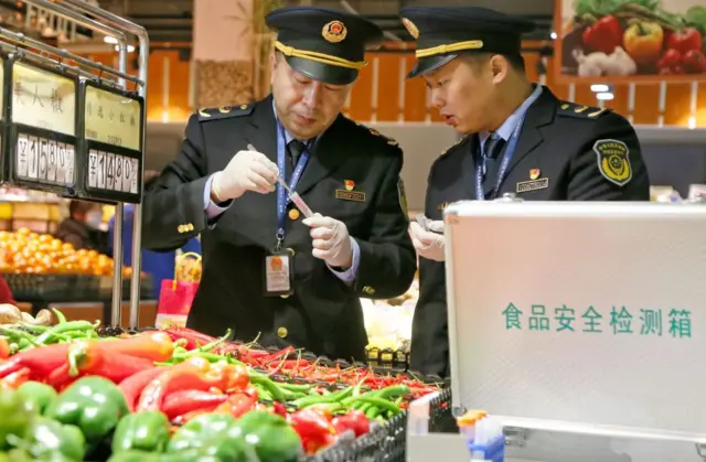 2024年2月1日，在中国东部江苏省海安市的一家超市里，市场监管人员使用食品安全检测设备检测蔬菜和其他食品中的农药残留。 