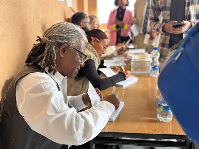 ዮናስ ጎርፌ በመጽሐፍ ምረቃ ወቅት ፊርማውን ሲያኖር