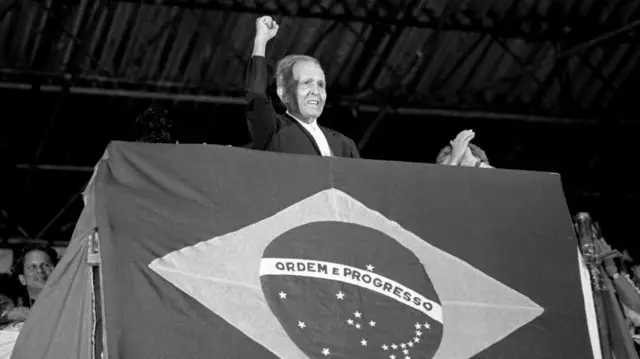 O ex-secretário-geral do Partido Comunista Brasileiro, Luis Carlos Prestes, levanta o punho enquanto faz campanhaum comícioLula durante o segundo turno das eleições. RioJaneiro, Brasil, 13dezembro1989.