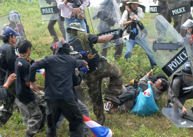 Members of People's Alliance for Democracy fight with local villagers during clashes near a disputed temple on the Cambodian border, northeastern Thailand on September 19, 2009. Dozens of people were wounded as Thai "Yellow Shirt" protesters clashed with local police and villagers near a disputed temple on the Cambodian border, the army said. Around 5,000 demonstrators from the PAD broke through barricades and gathered at the foot of the 11th century Preah Vihear temple, the scene of several deadly battles between Thai and Cambodian troops over the past year, an army spokesman said. AFP PHOTO/STR - - Thailand out - - (Photo by AFP) (Photo by STR/AFP via Getty Images)