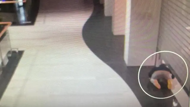 Zanlı kapalı kepenklerin ardından sürünerek bir mağazaya girdi