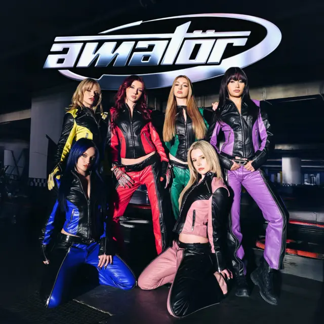 Manifest grubu üzerlerinde yarış kiyafetleriyle "Amatör" yazısının altında poz veriyor.