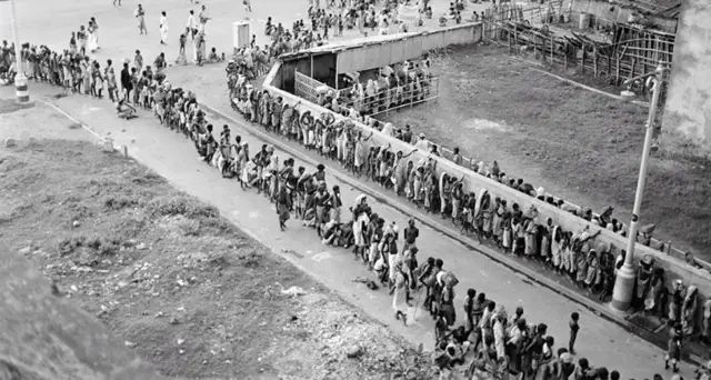 खाना पाने के लिए कलकत्ता में लाइन लगाकर खड़े लोग