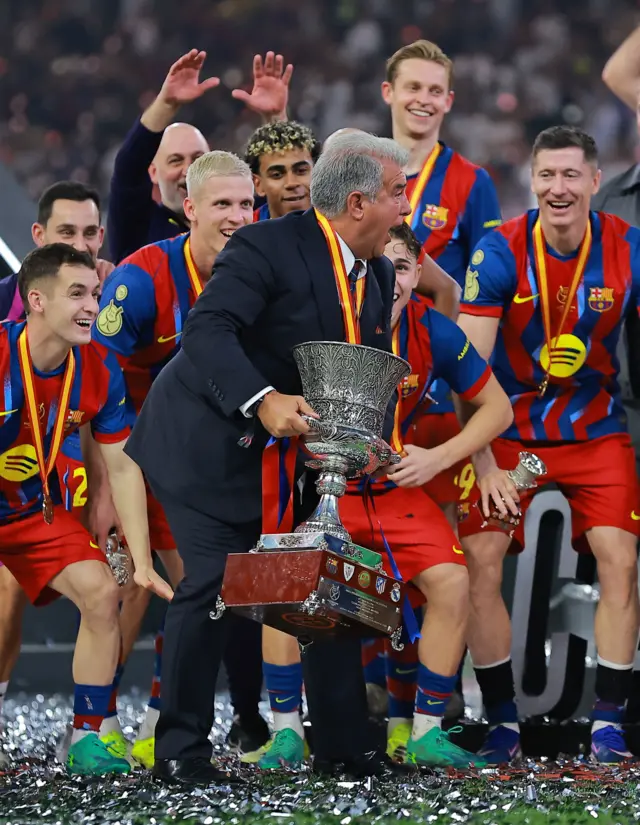 بازیکنان و مربی بارسا هنگام بلند کردن جام