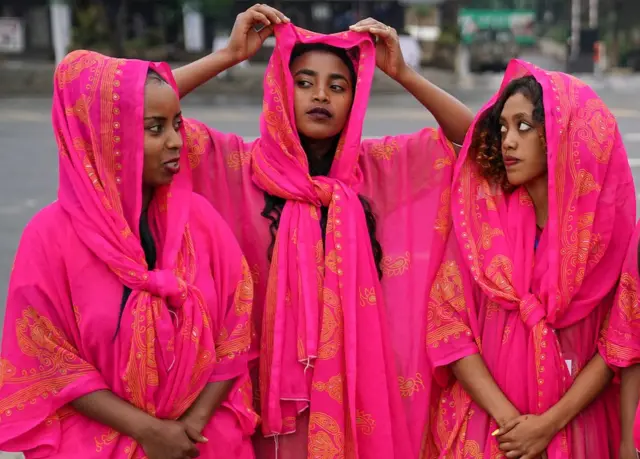Three women dressed in traditional dresses of the Harari culture of eastern Ethiopia