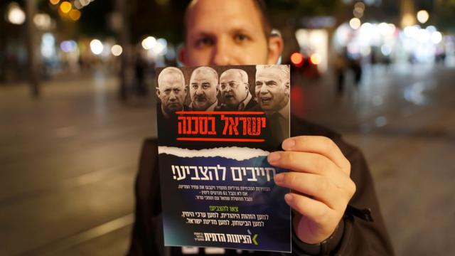 Un militant du sionisme religieux montre à la caméra un tract qu'il distribue dans les rues de Jérusalem.