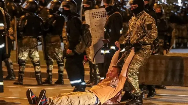 Сотрудник ОМОН тащит мужчину за руки