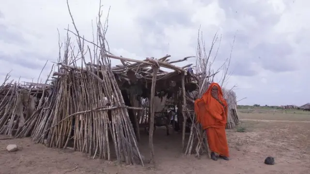 امرأة أمام مأوى بدائي 