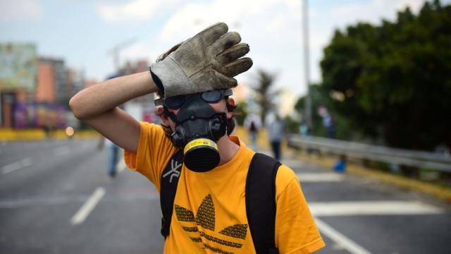 Opositor venezolano con máscara y guantes
