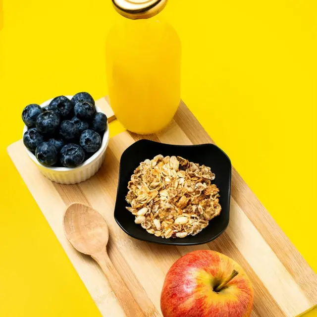 Yaban mersini, yulaf, elma ve portakal suyu ahşap zeminde duruyor. 