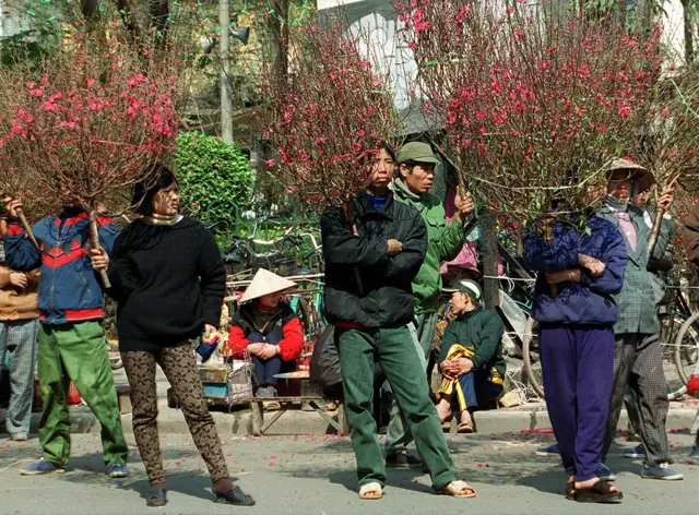 Chỉ còn vài ngày nữa là Tết, nhiều người dân bán đào tại trung tâm Hà Nội chào mời khách mua hoa vào ngày 1/2/2000, tức 26 tháng Chạp âm lịch.