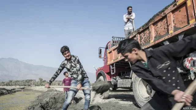 તળાવમાંથી રેતી ભરતા લોકો