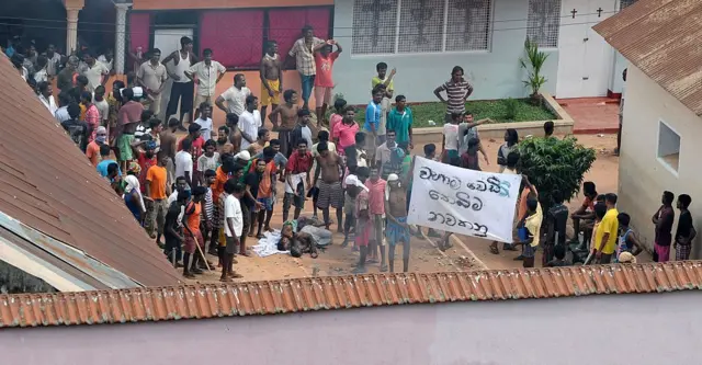 Sri Lankan prisoners gather arround inju Sri Lankan prisoners gather arround injured inmates in a courtyard during riots at the main prison in Colombo on January 24, 2012.