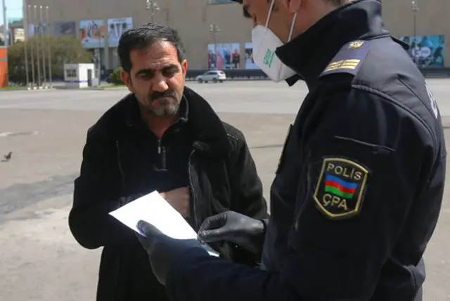 Полицейский в Баку проверяет прохожего
