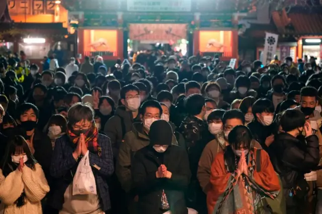 Wearing masks, people in Tokyo visit the Shinto Kanda Myojin Shrine to mark the new year