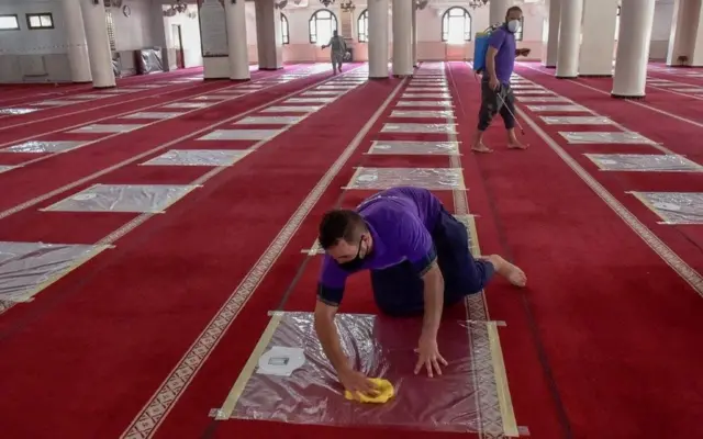 Des volontaires algériens désinfectent la salle de prière avant la prière de midi à la mosquée El Fateh dans le quartier El Afia de Kouba de la capitale Alger, le 15 août 2020.